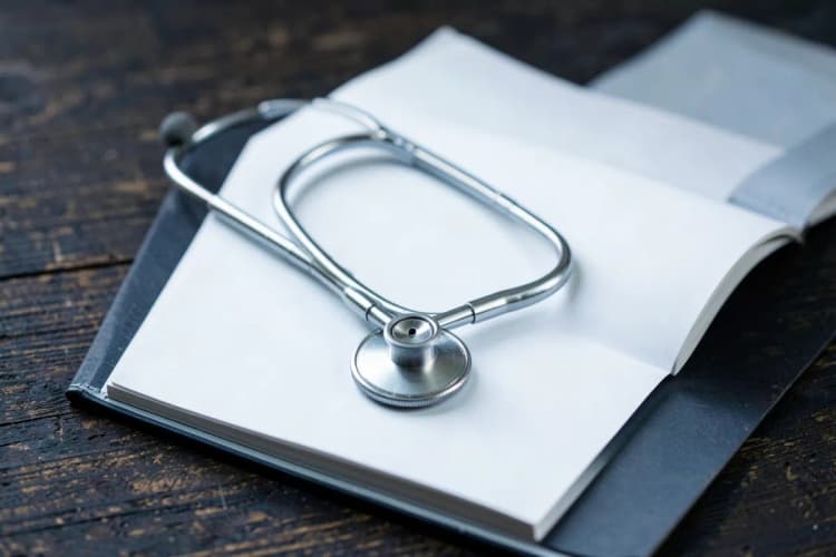 Um estetoscópio sobre um prontuário médico aberto.