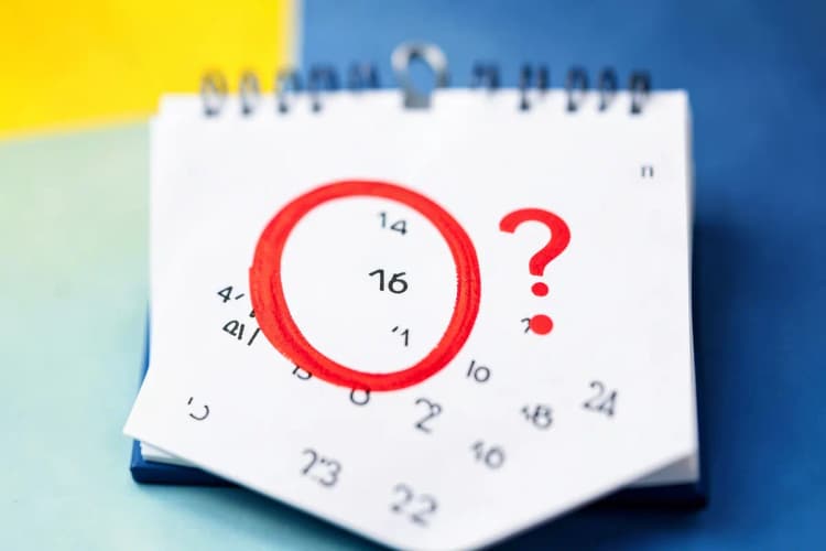 Um calendário com um dia marcado com um círculo vermelho e um ponto de interrogação ao lado.
